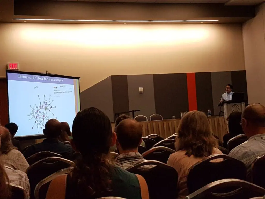 Conference audience watching presenter and network diagram